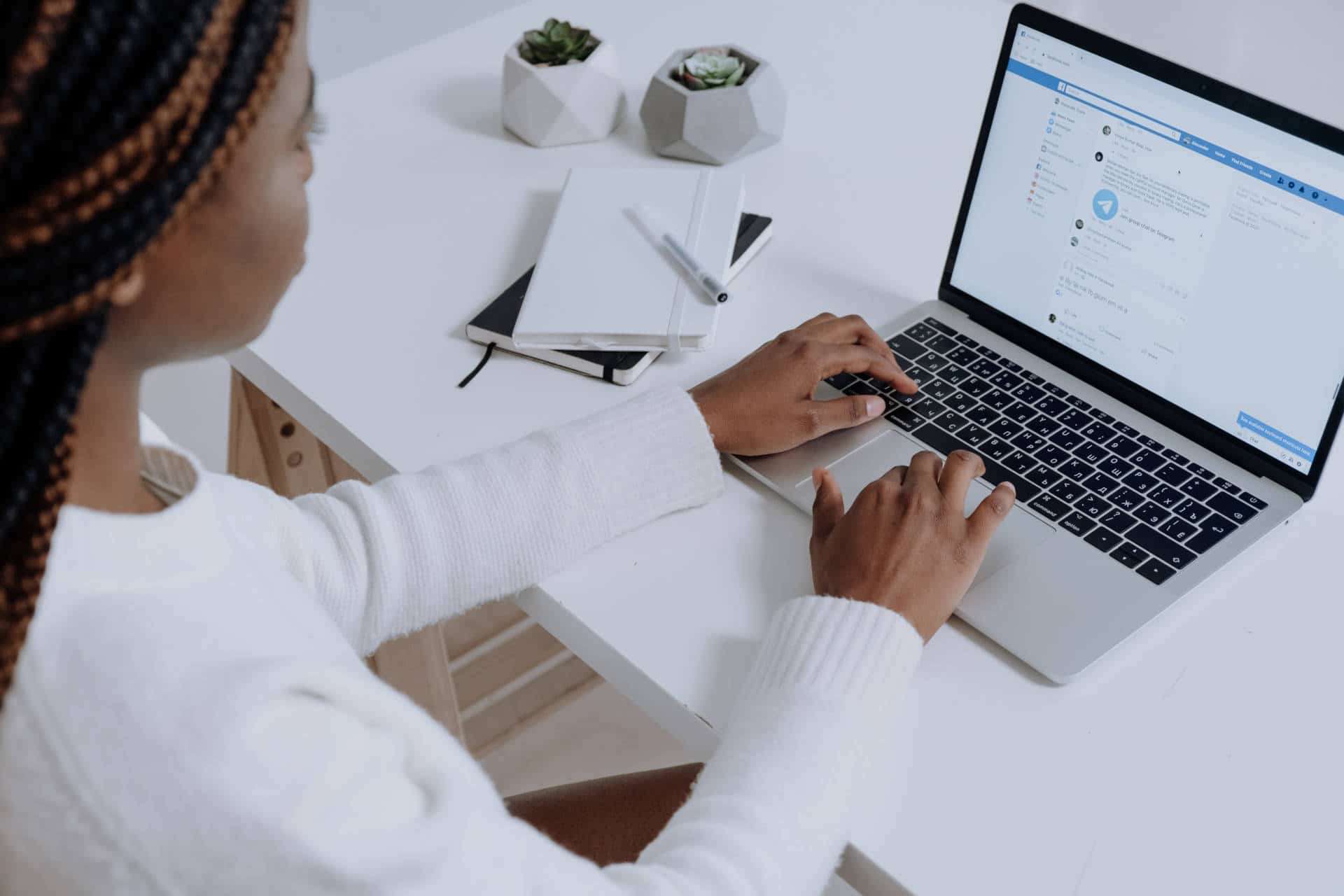 A woman is displaying Facebook on a laptop